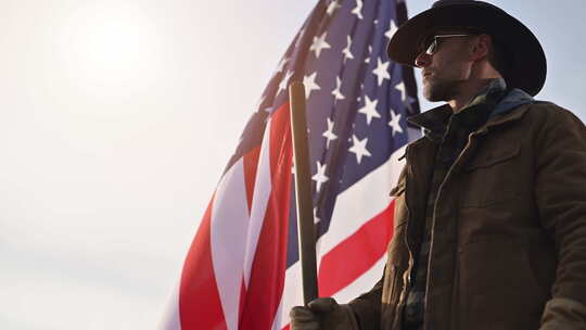 骄傲的美国牛仔呆在国旗旁边视频素材模板下载