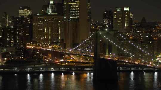 汽车在夜间空中驶过布鲁克林大桥