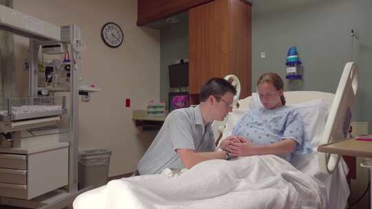 医院病床上的男人和孕妇