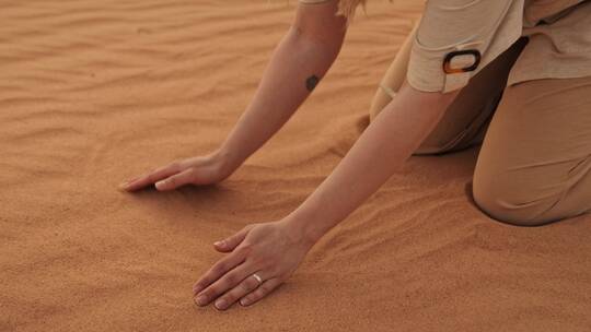 女人在沙漠中捧沙子