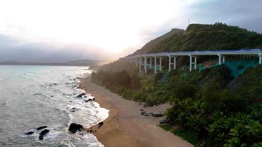 航拍大海落日天空海边的沿山公路三亚