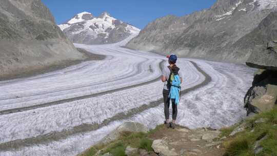 一个孤独的女性徒步旅行者看着一个巨大的冰