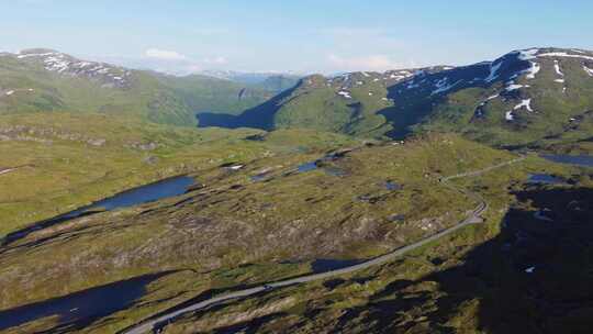 挪威Vikafjell山顶上有过往汽车的弯曲山路-傍晚的夏季日落ae
