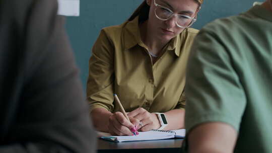 女学生在英语课上跟着老师做笔记