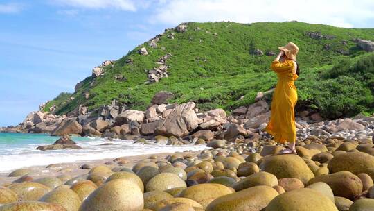 海南万宁大花角一个美女在鹅卵石上看海