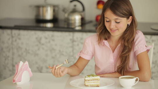 女孩坐在桌旁吃蛋糕