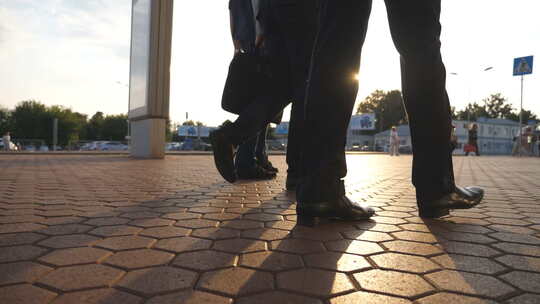 三名商人在机场附近行走的脚，背景是太阳耀斑