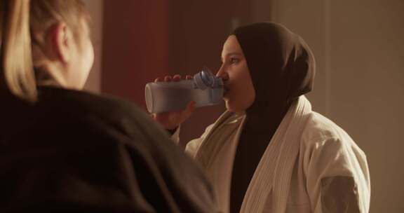 穆斯林战士喝水并与教练交谈