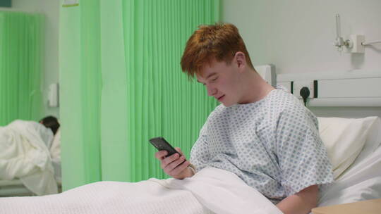 病床上的男士看手机 