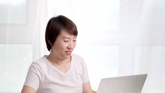 夏天使用笔记本电脑办公的东方年轻女性视频素材模板下载