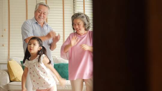 幸福家庭小女孩和爷爷奶奶跳舞