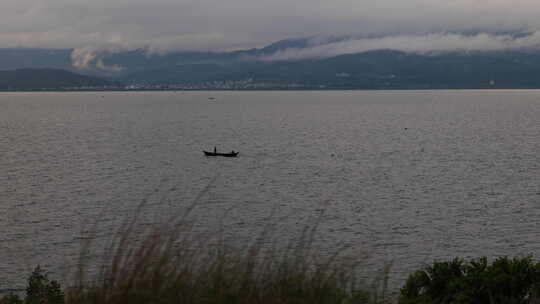 云南松茸地拍抚仙湖湖中小船远山云彩