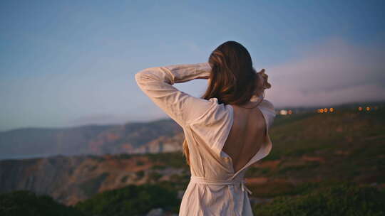 浪漫的女士在海洋悬崖上跳舞日落大自然做轻