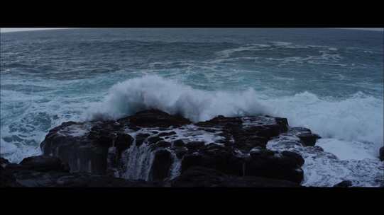 黑暗的日子里，海浪拍打着岸边的大石头