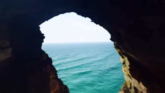 穿越机穿过海边岩石洞口直达海面旅行风光