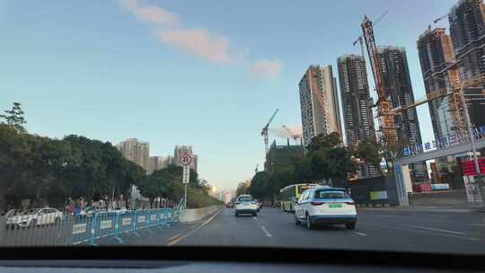 在建高楼旁车来车往的城市道路景象