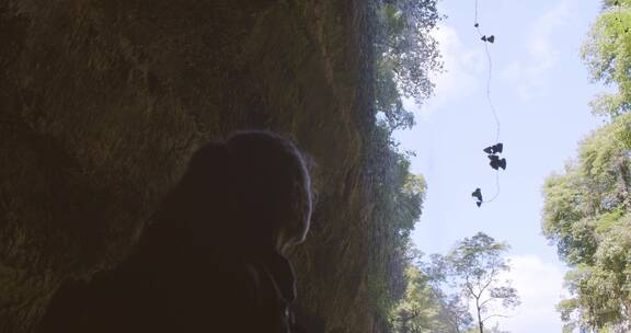 女孩站在悬崖边观赏瀑布
