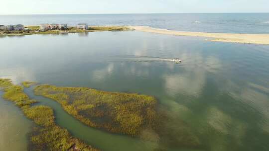 北卡罗来纳州橡树岛的鸟瞰图。一艘渔船沿着水道行驶的景色