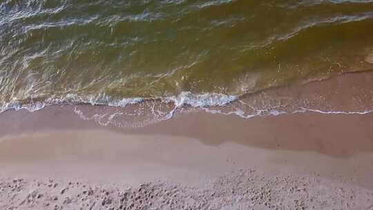 波罗的海沙滩上海浪的鸟瞰图。4k无人机拍摄的海浪撞击商店的镜头