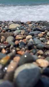 海水浪花冲刷鹅卵石素材