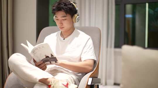 男生在客厅里听音乐读书