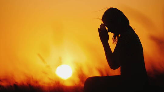女人在日落时祈祷