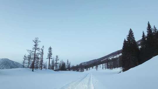 冬季喀纳斯湖雪山脚下汽车在积雪路面上行驶