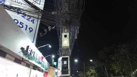 夜晚街边杂乱的电线和店铺