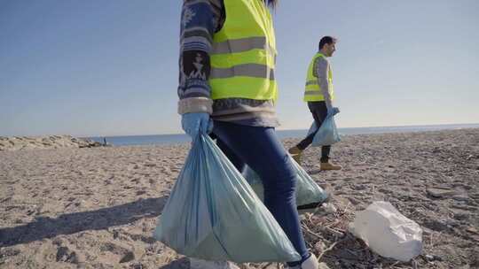 一群志愿者在海滩上捡垃圾环保活动人士视频素材模板下载