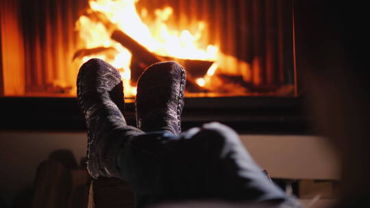 壁炉背景下穿着袜子的脚在炉火旁取暖视频素材模板下载