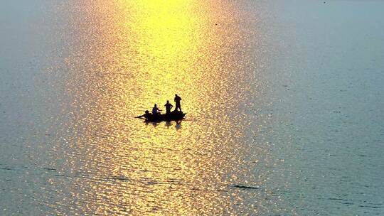 暖色夕阳下湖面上渔船渔民升格