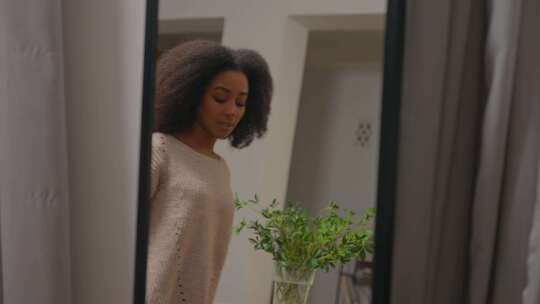 不快乐的非裔美国女人在家照镜子穿套头衫休
