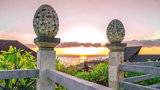 巴厘岛阿梅德海滩日出与海面背景下的灯笼花卉图案雕塑沙石视频素材模板下载