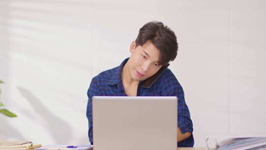 企业家英俊的商业亚洲男子穿着蓝色衬衫在笔记本电脑办公桌上在线工作视频素材模板下载