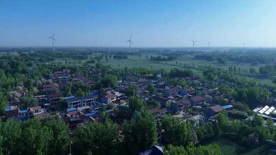 村庄绿色庄稼地风力发电大风车后飞视频素材模板下载
