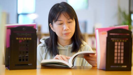 年轻女子图书馆在书架前翻看书本学习