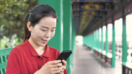中国女性路边玩手机拍照通讯聊天