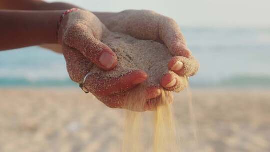 女性手释放落下的沙粒沙子轻轻落下