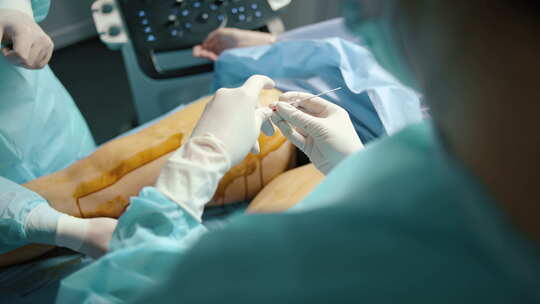 外科医生在医院手术室为病人进行静脉手术