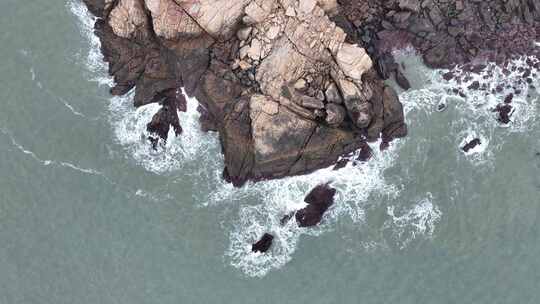 海岸礁石海水拍打礁石阴天海滩岩石海浪冲刷