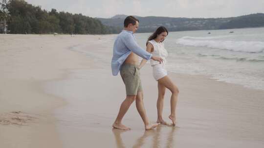情侣手牵手在沙滩上散步拥抱视频素材模板下载