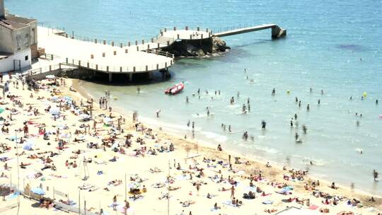 码头旁边挤满了游客的海滩