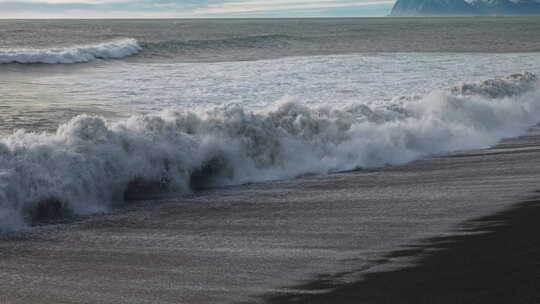 海浪拍打着黑色沙滩视频素材模板下载