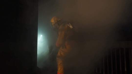 消防员在充满烟雾的大楼里营救一名受害者