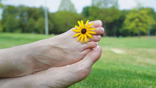 坐在公园 放松 脚趾上花朵
