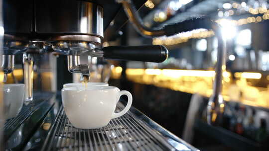 餐厅的专用咖啡机将咖啡倒入杯子