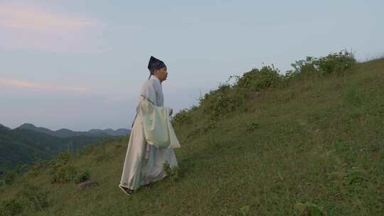 古装男子漫步山间草地