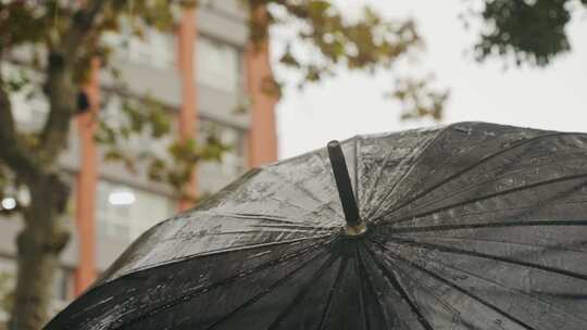 雨中欧洲城市路灯上带伞和雨衣的商人游客