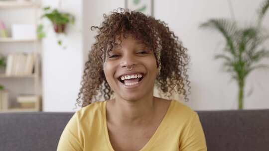 非裔妇女坐在沙发上对着镜头微笑
