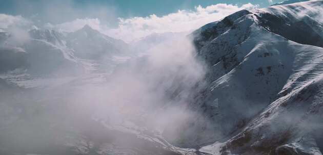 航拍阿尔卑斯山脉的积雪和云雾环绕